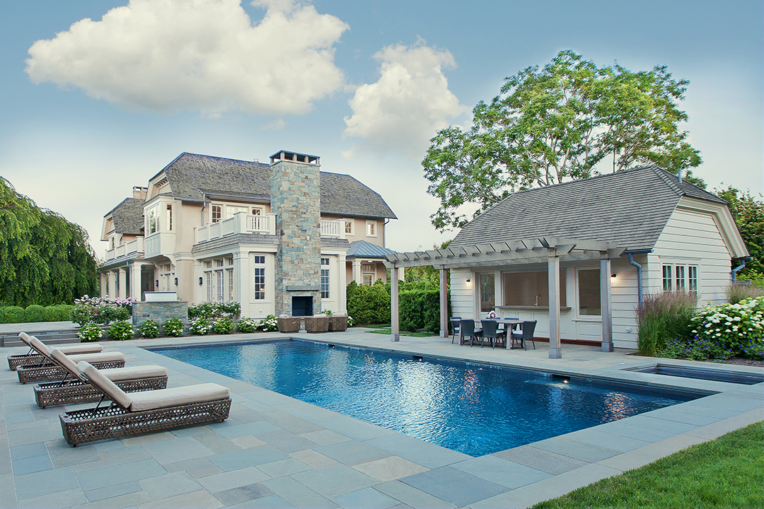 Exterior shot of home, pool, and dining area.