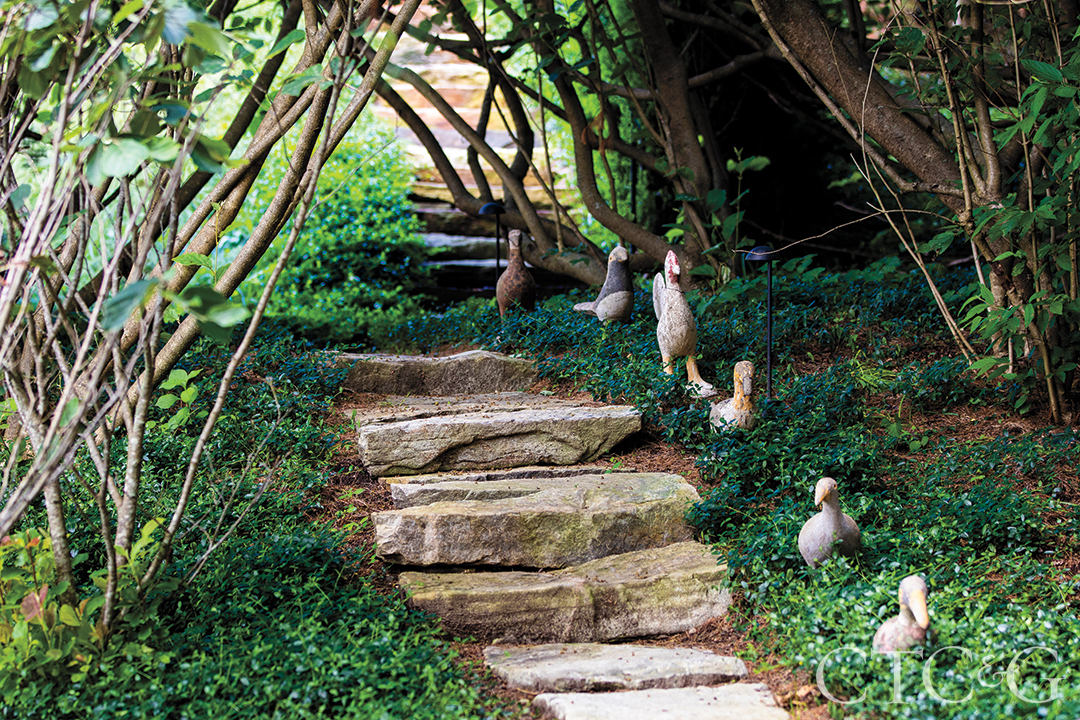Stone stairs lead upwards, lined with duck statues.