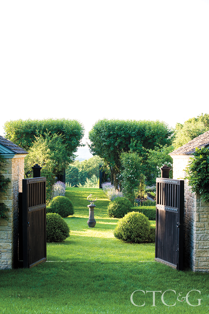 Gates open up to a lush green garden.
