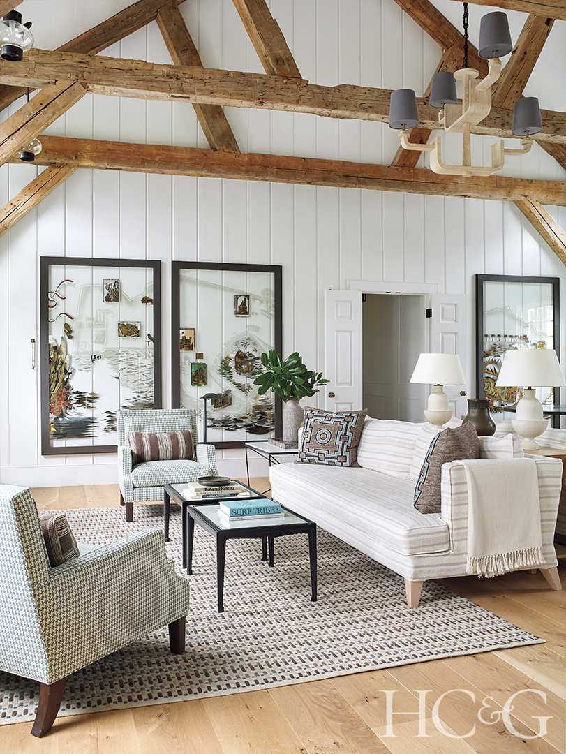A white sofa and two armchairs arranged in a carpeted living room.