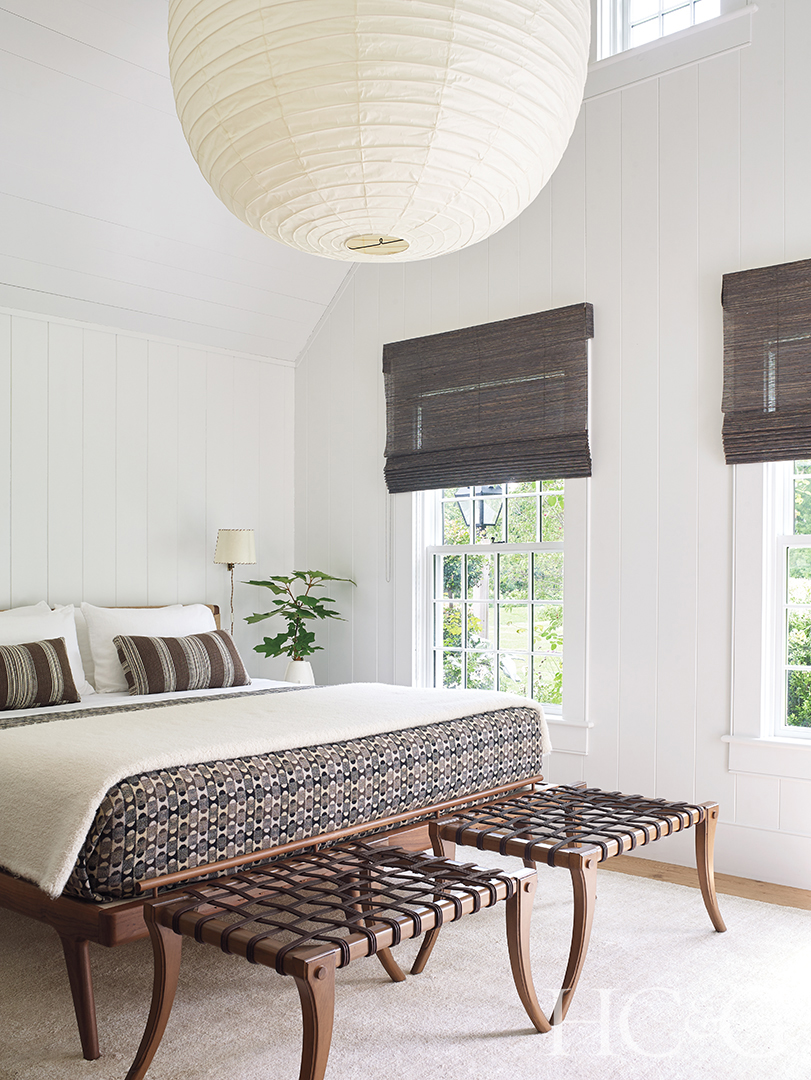 Two woven benches sit at the foot of the master bed.