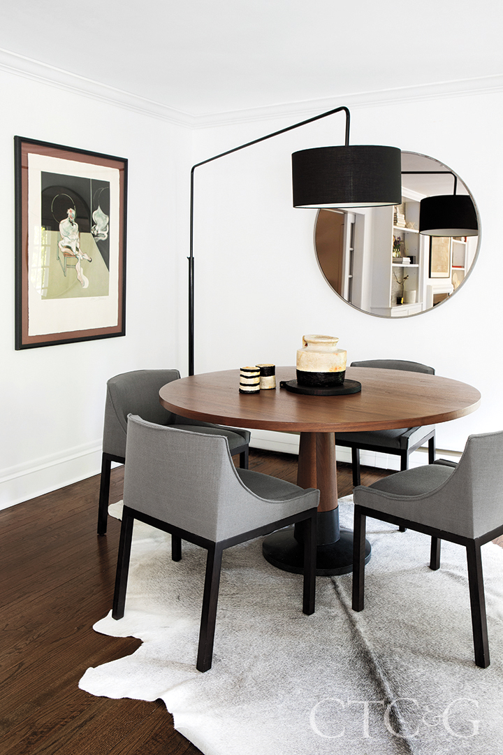 black floor light, table, and chairs in dining room; decorative mirror and wall art