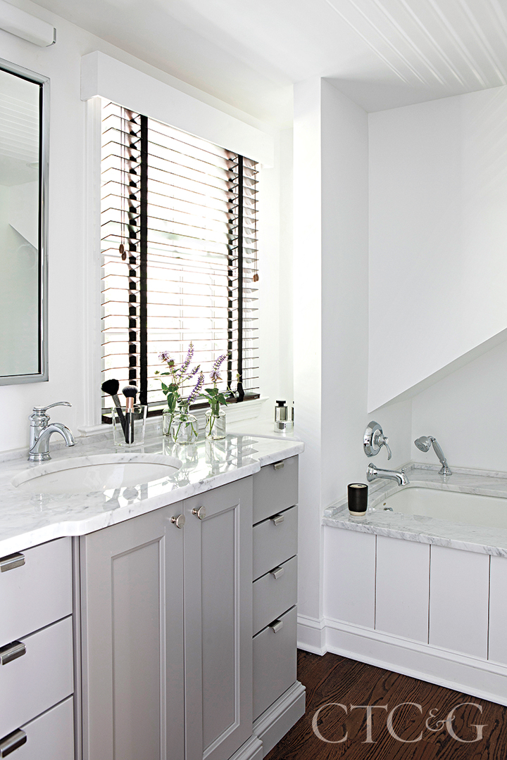 gray and white main bathroom; white marble counters and tub