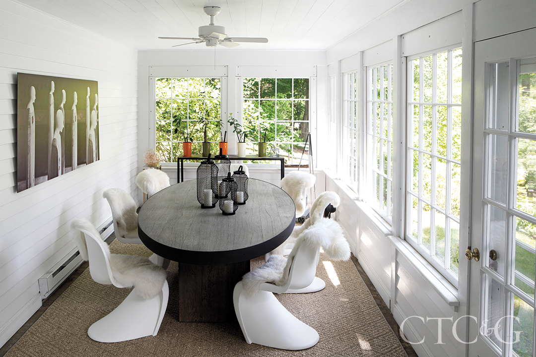 panton chairs with sheepskins and custom oak-and-steel table in sunroom