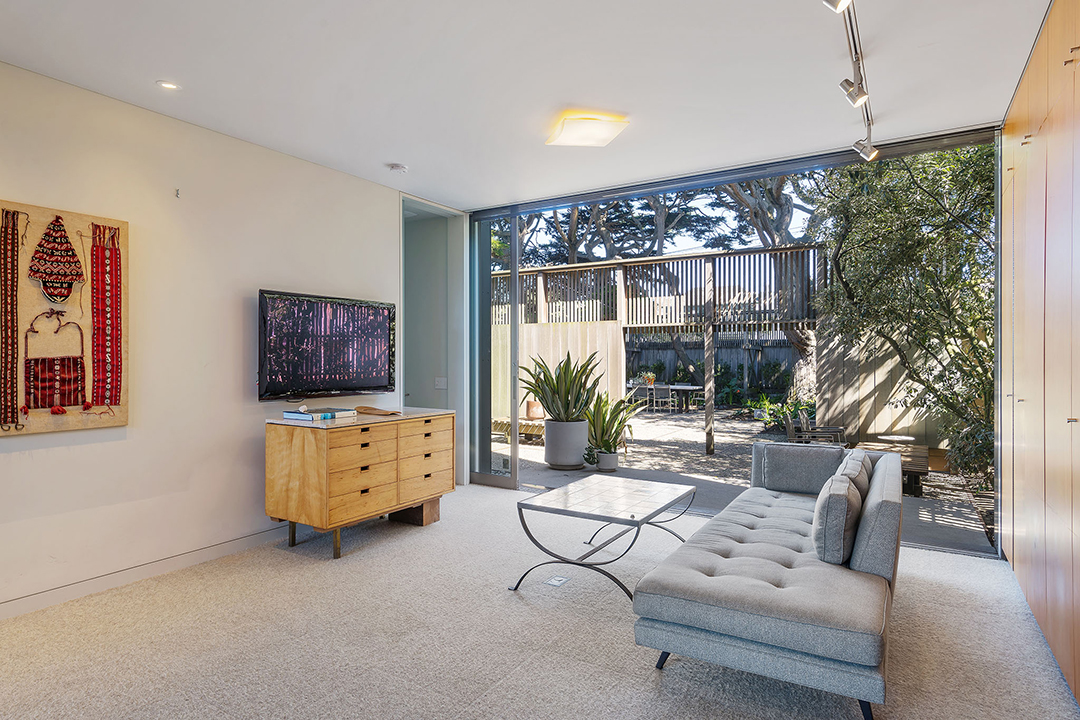 Midcentury den that opens to a landscaped backyard