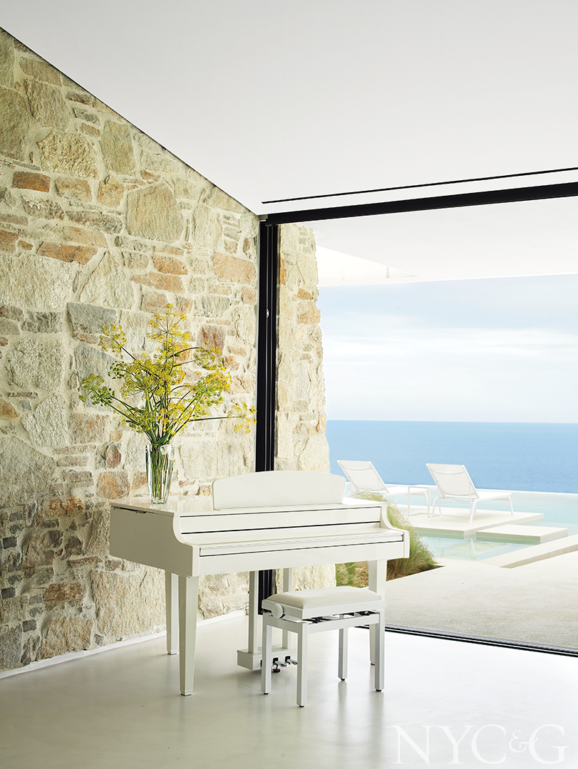 white piano and view of pool and ocean