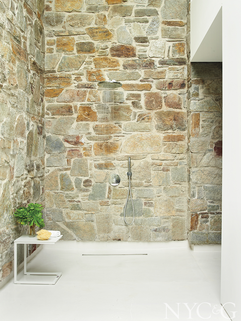 shower with stone walls and white flooring
