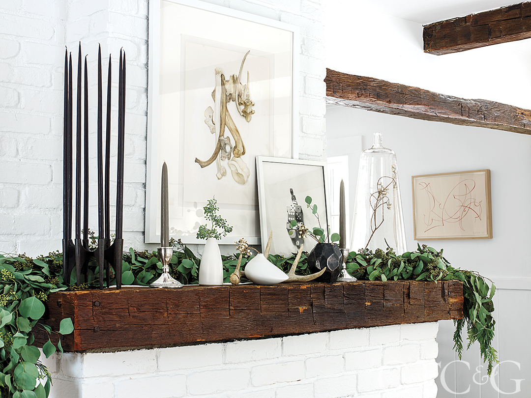 Holiday mantel with greenery and art
