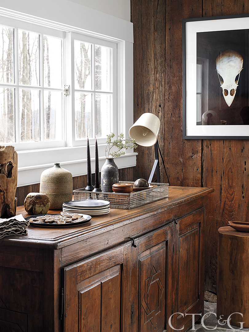 An antique credenza and bird skull photograph in a TV room