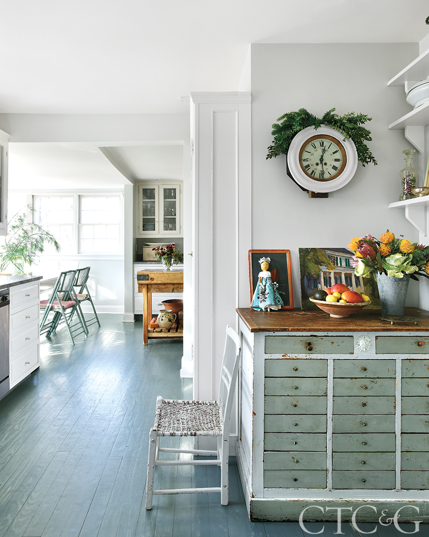 Antique chair and sideboard outside of farmhouse kitchen decorated for holidays