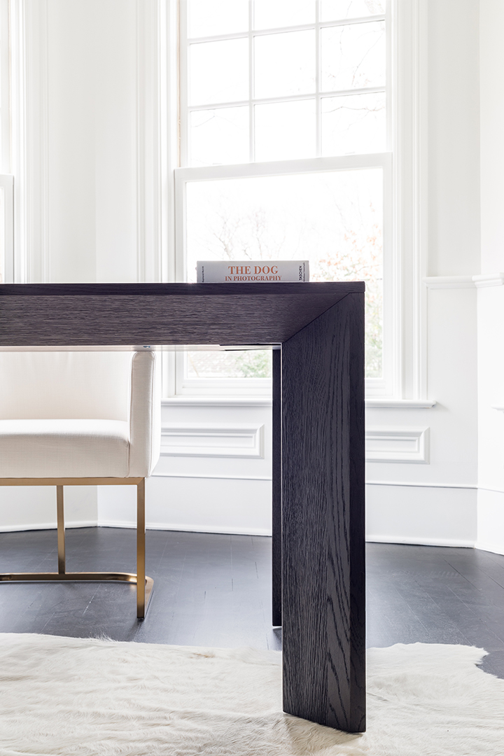 Dark wood desk in a bright office space