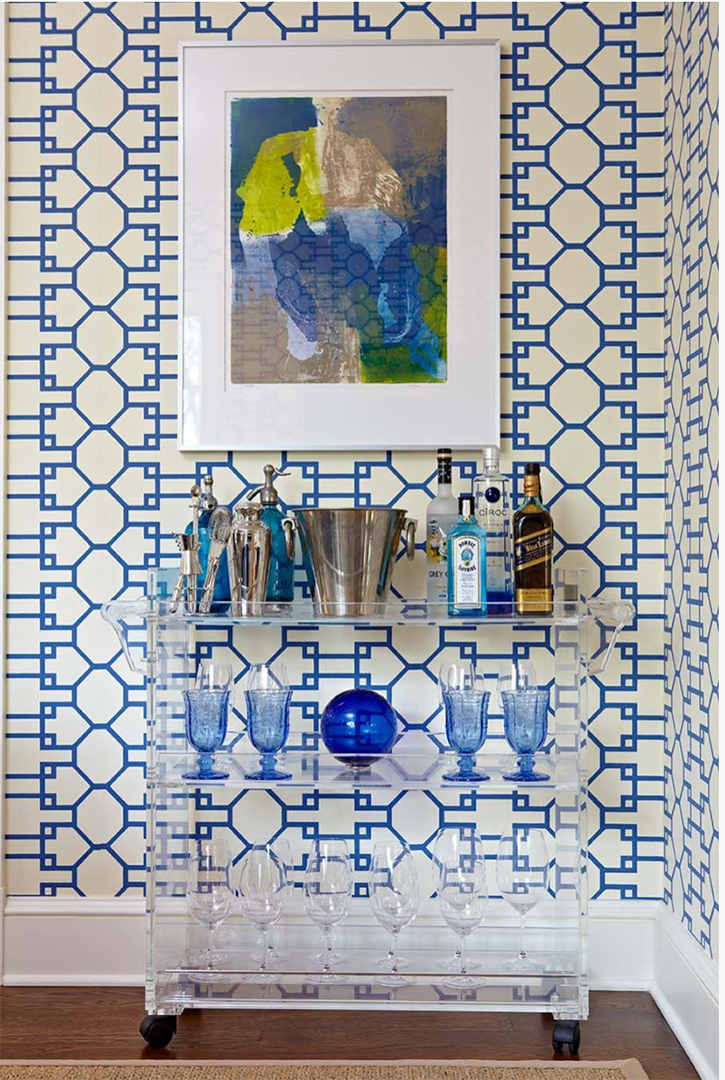 Decorative bar nook with fun wallpaper and lucite cart.