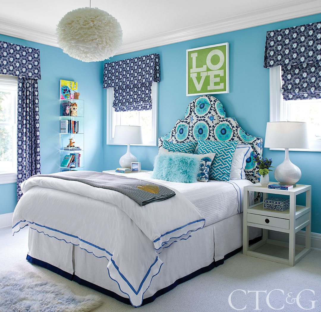 bedroom with blue walls, navy patterned curtains, and a patterned headboard