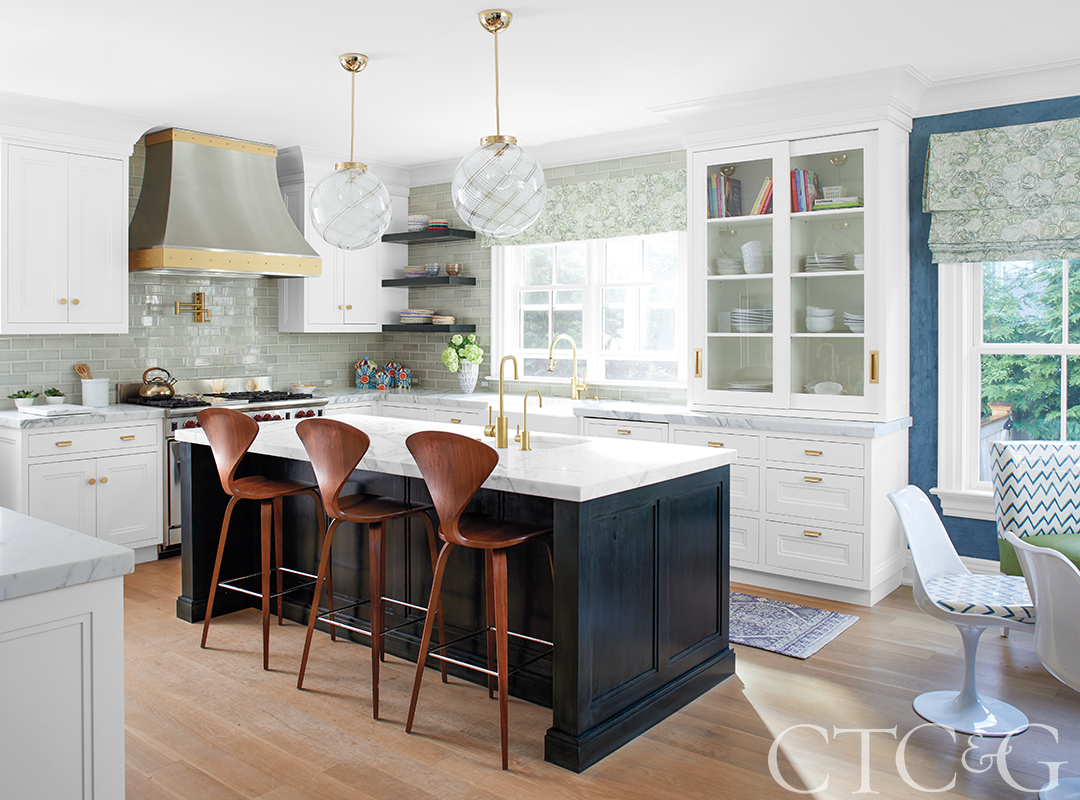 kitchen with white cabinets and a black island with wooden stools.