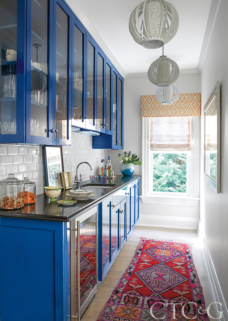 pantry with blue cabinets and a red and purple runner.