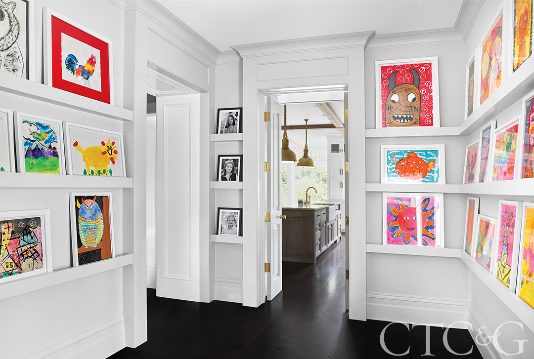 Hallway turned picture-gallery leading into the kitchen.