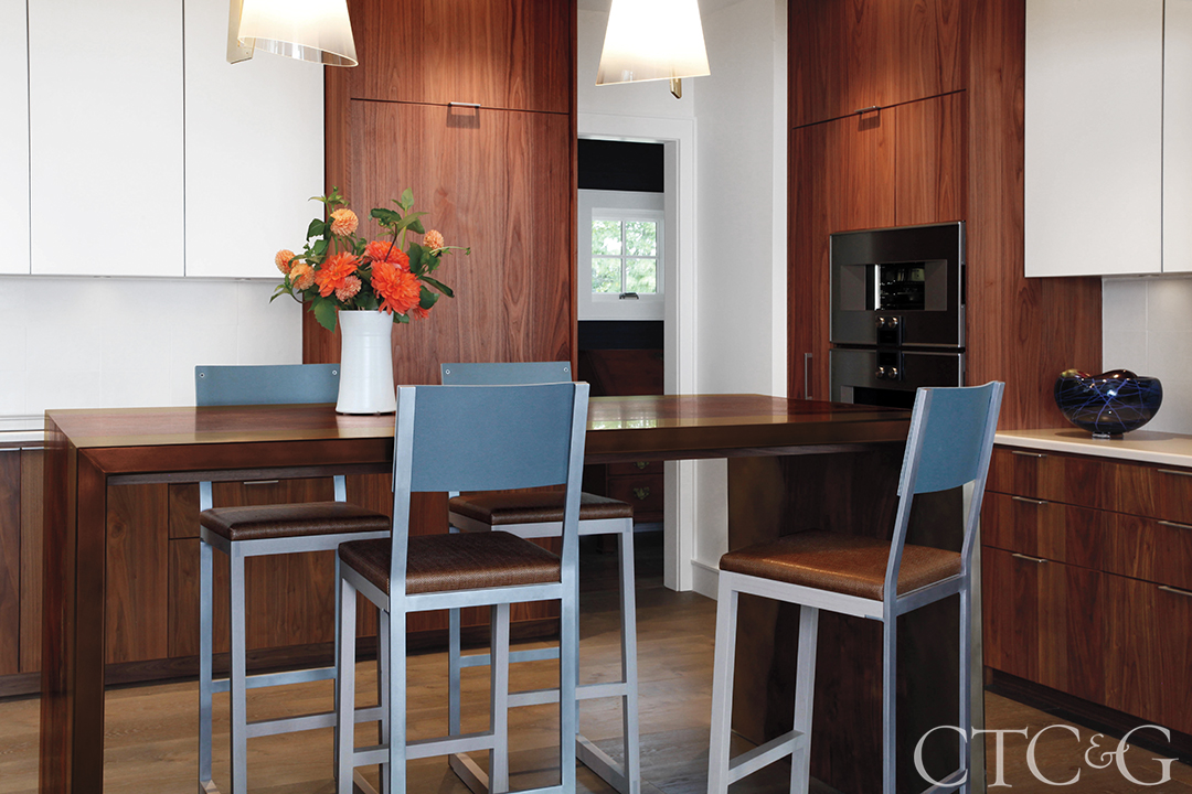 View of the modern kitchen with a eat in area and appliances.