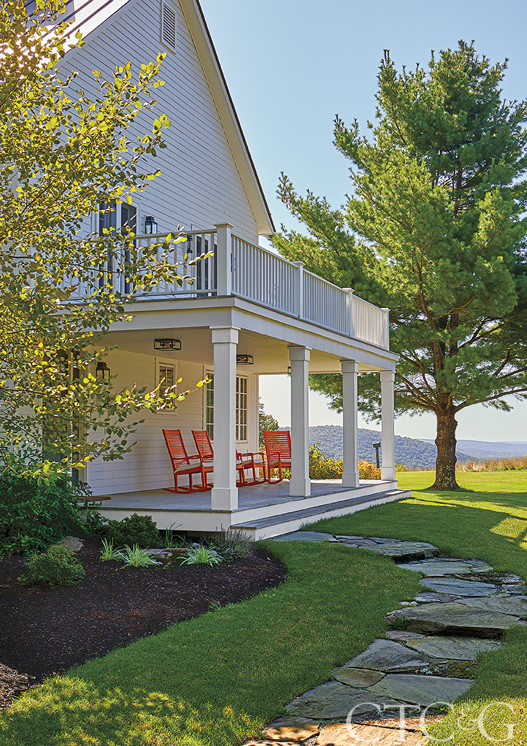 White home with porch overlooking green landscape