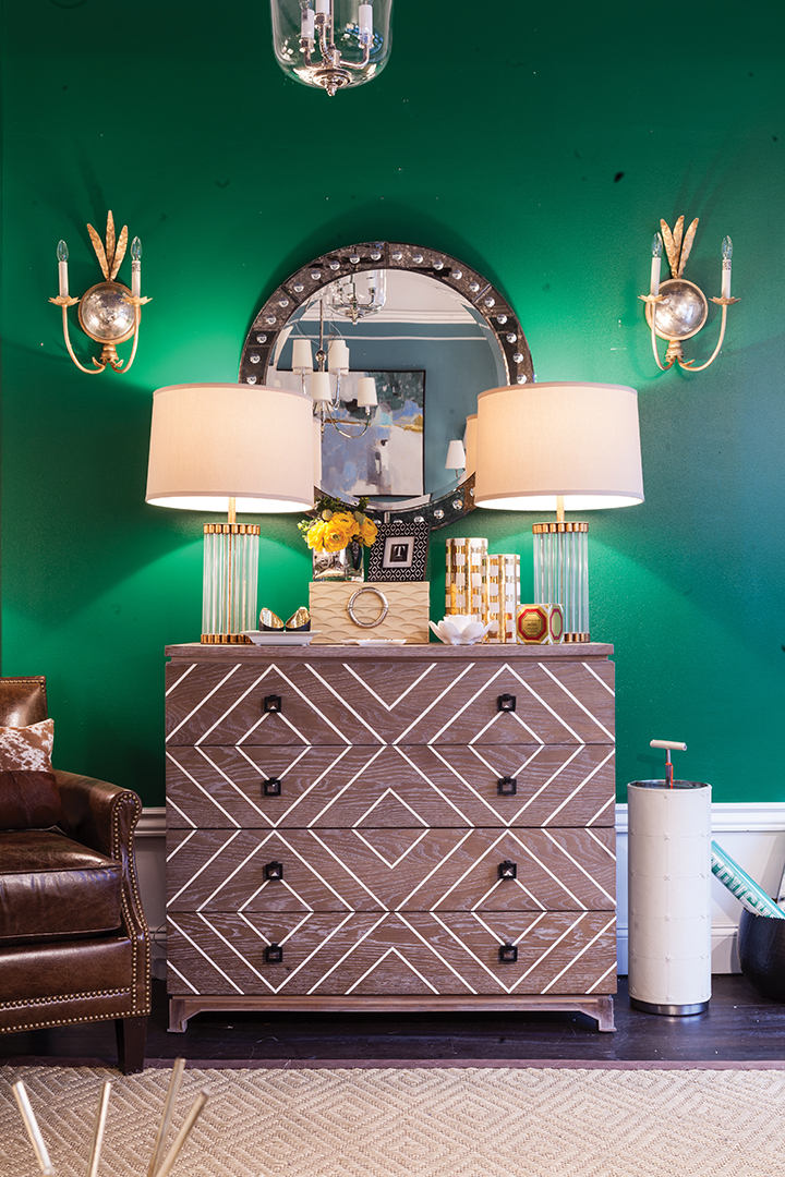 dresser with green walls and lamps.