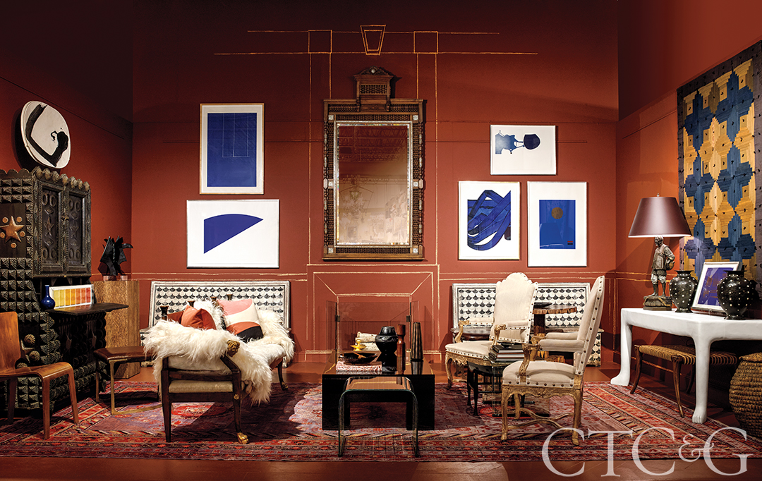 Sitting area with white chairs and sofa, and large abstract art on the wall.