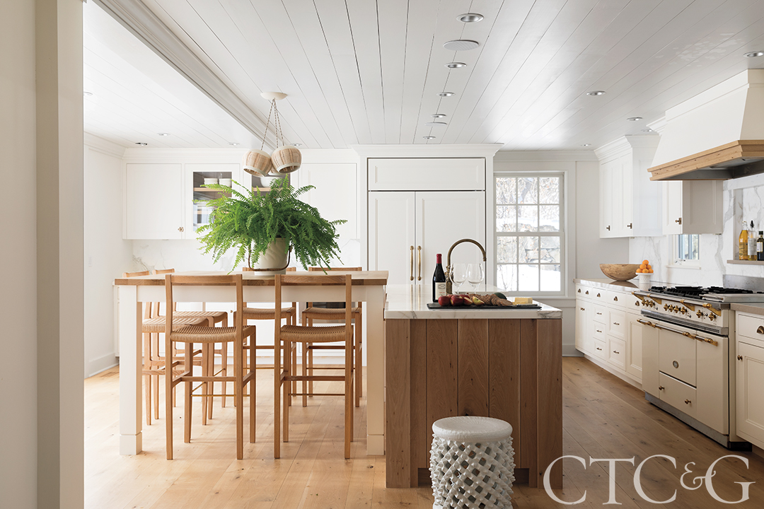 kitchen with white cabinets and wood and brass accents with wood floors.