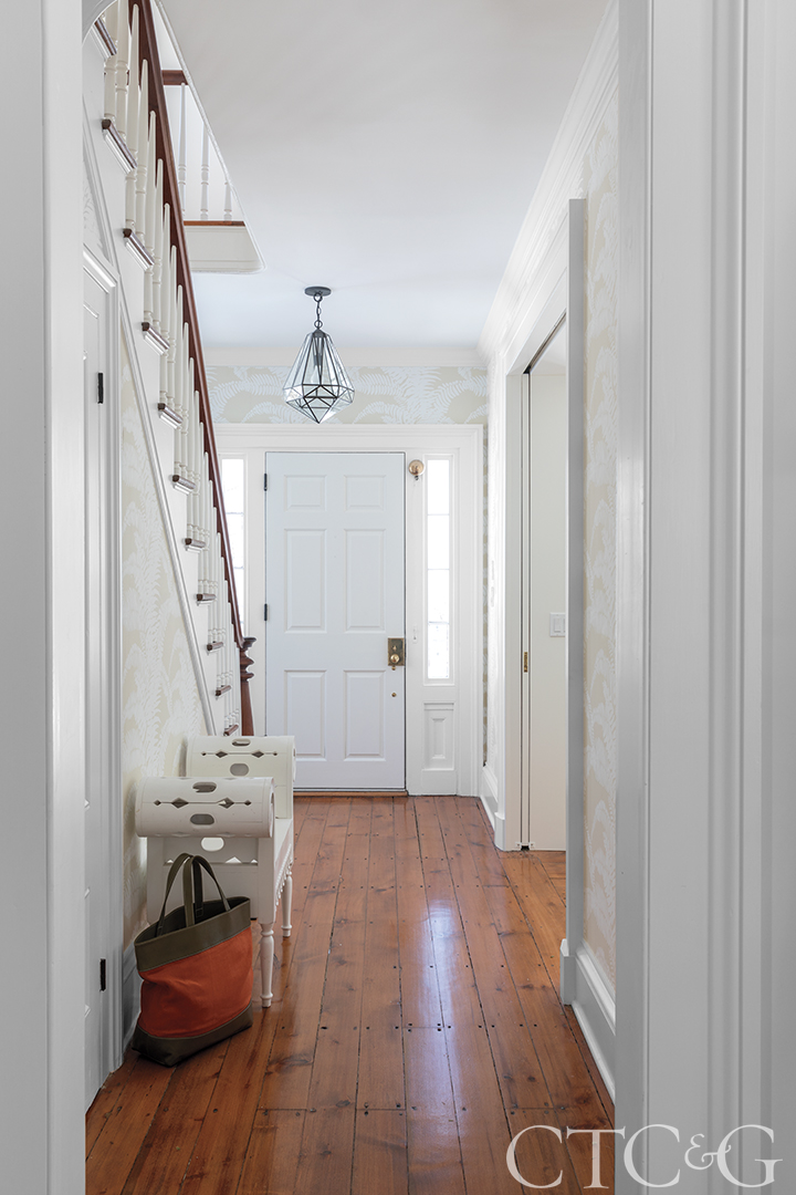 Entryway with hardwood flooring, chandelier, and the staircase.
