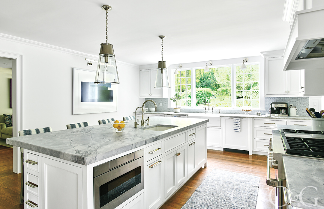 View of the coastal kitche with lots of natural light and a long kitchen island.