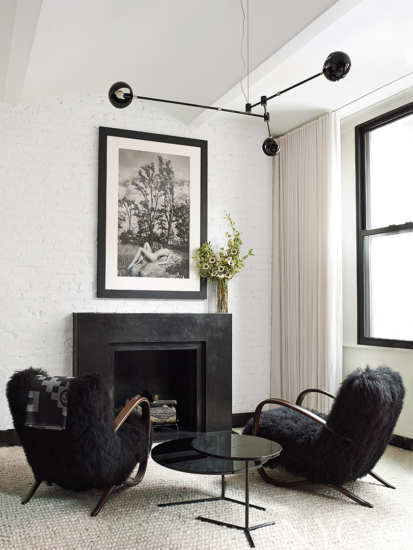 contemporary black and white seating area around fireplace with black sheep fur chairs