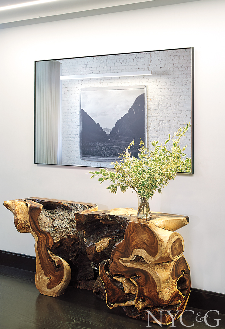 white painted brick wall, black floor, and wood tree side table