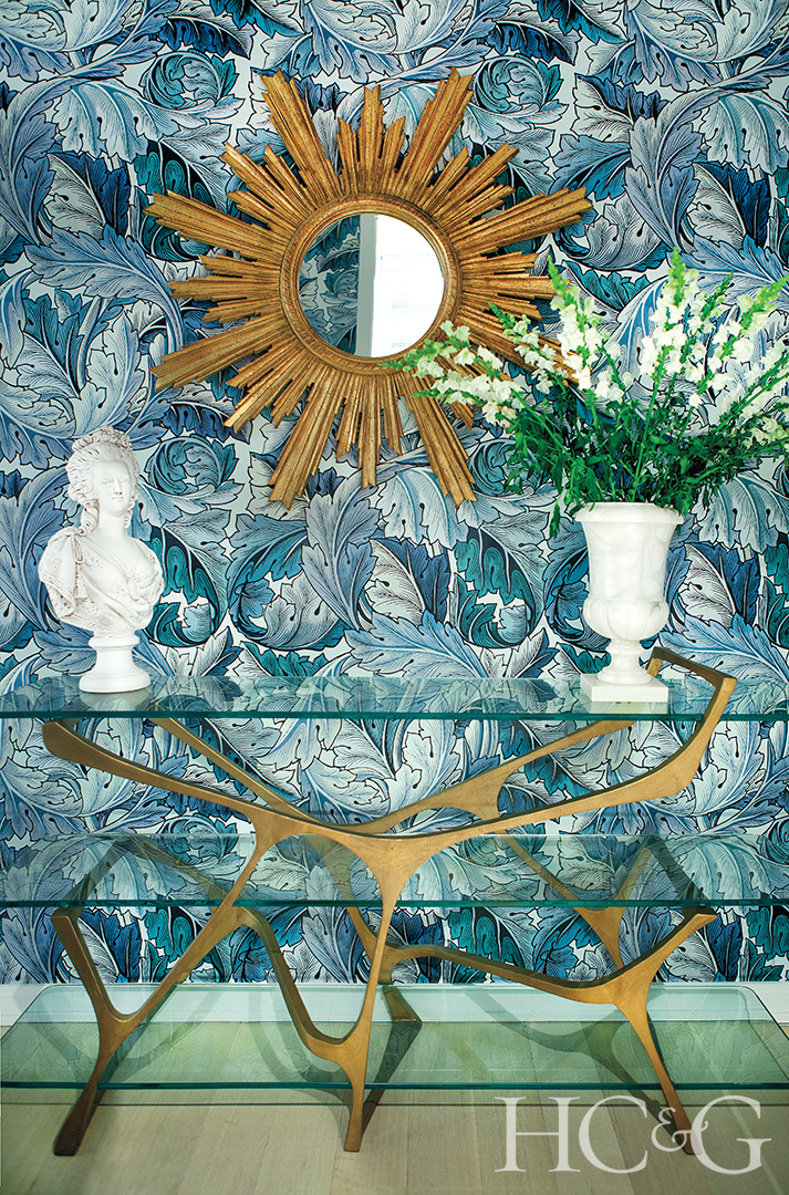 blue patterned wallpaper entry; side table and decor
