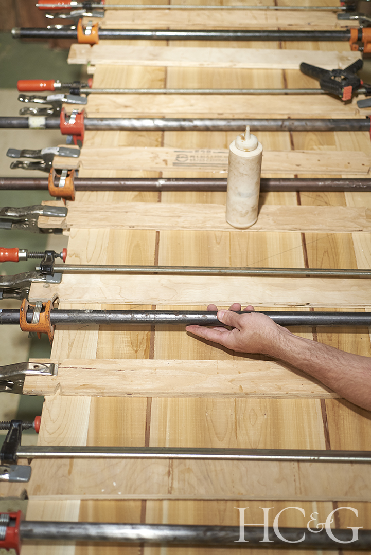 Metal rods span horizontally across the wooden planks of a surfboard.