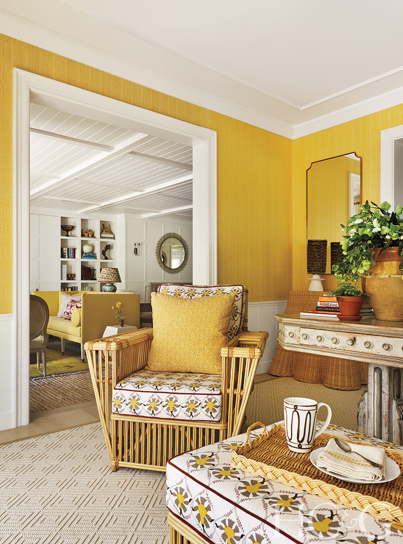 A yellow wicker armchair sits in a sunny yellow room.