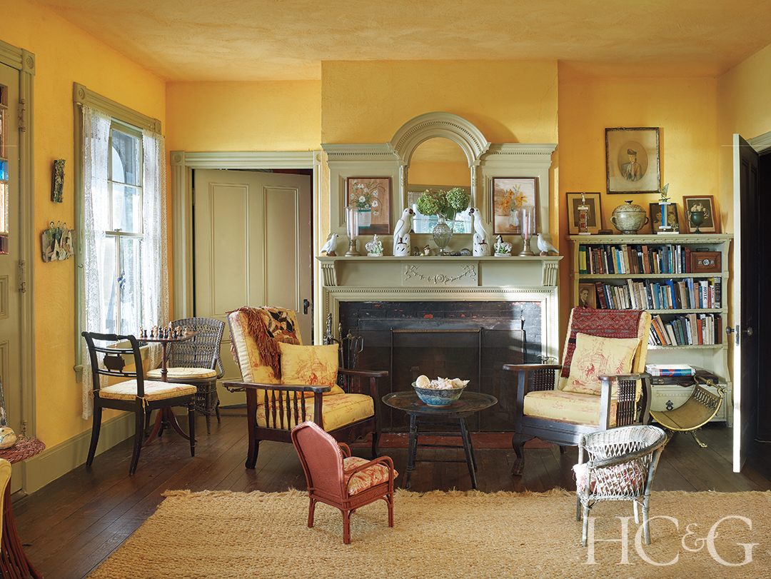 A predominately yellow living room with multiple chairs and a single table.