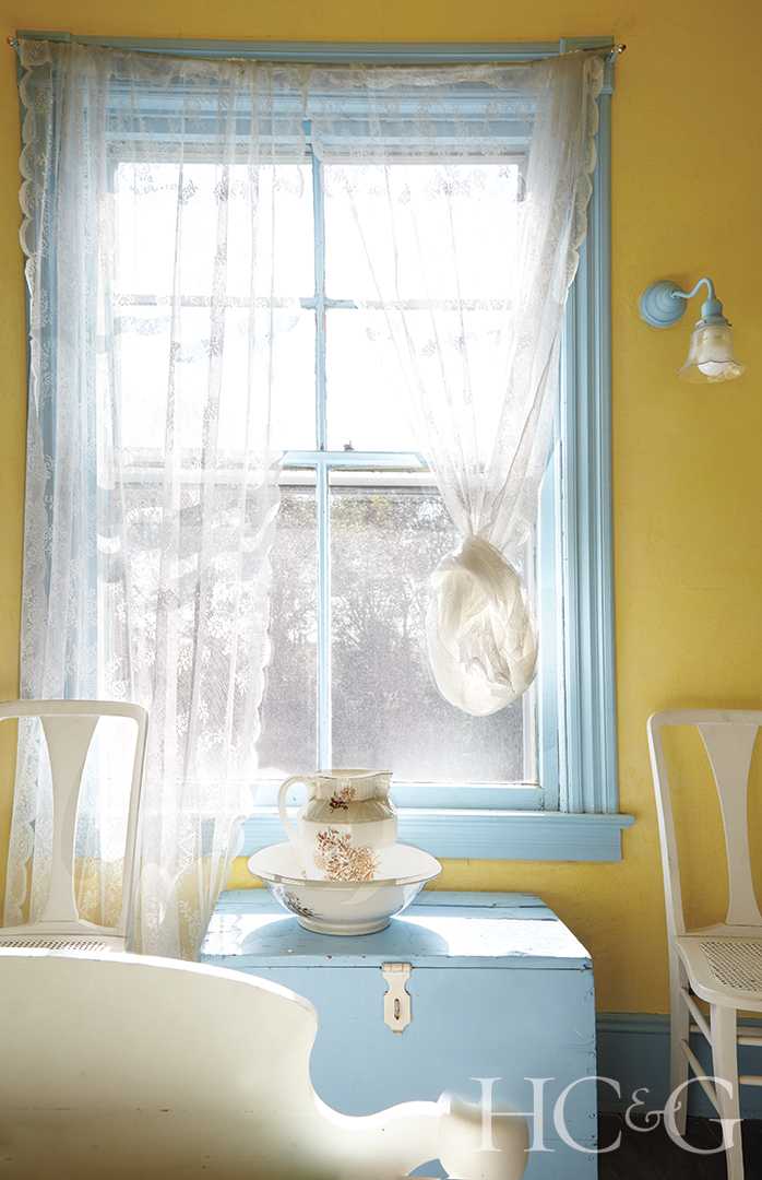 A baby blue window frame in a light yellow room.