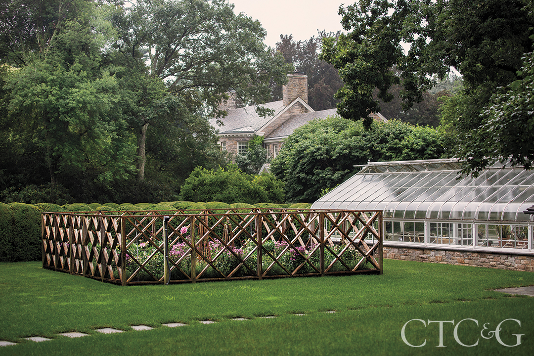 A garden surrounded by a wood lattice fence.
