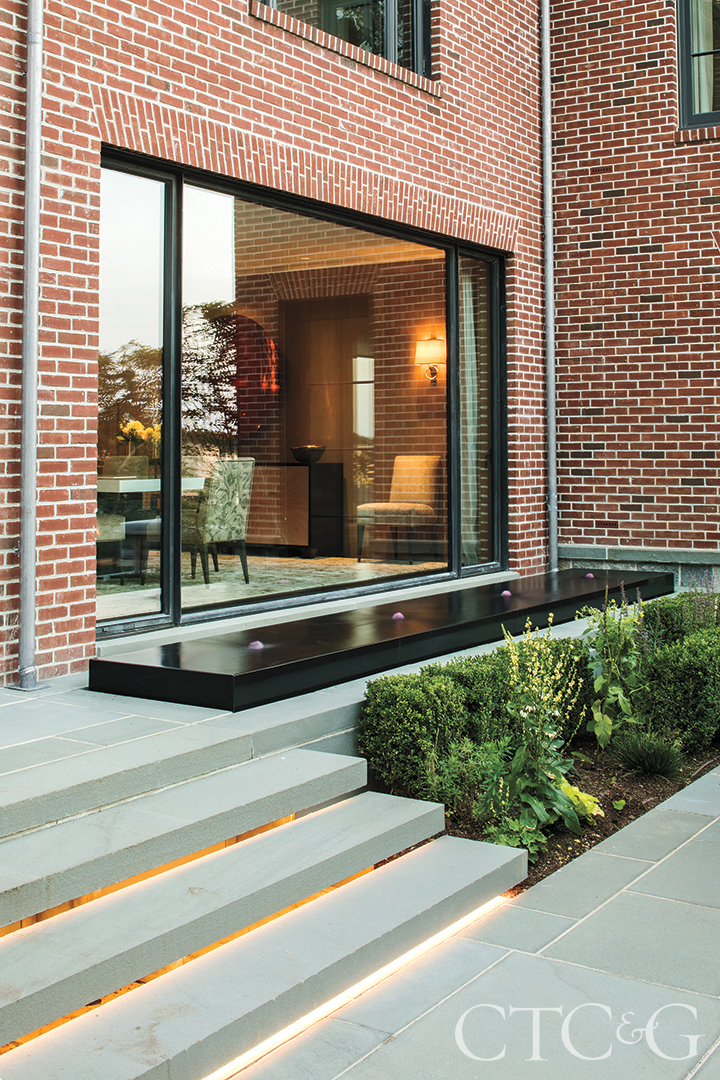 Greenwich Tudor Brick Home Exterior With Dining Room Window And Water Feature