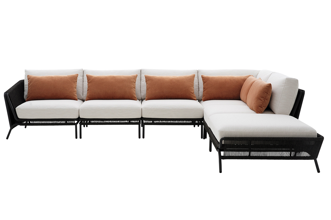 A five-segmented sofa with white cushions and burnt orange pillows.