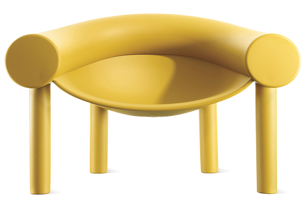 A curvy yellow arm chair with a rounded back.