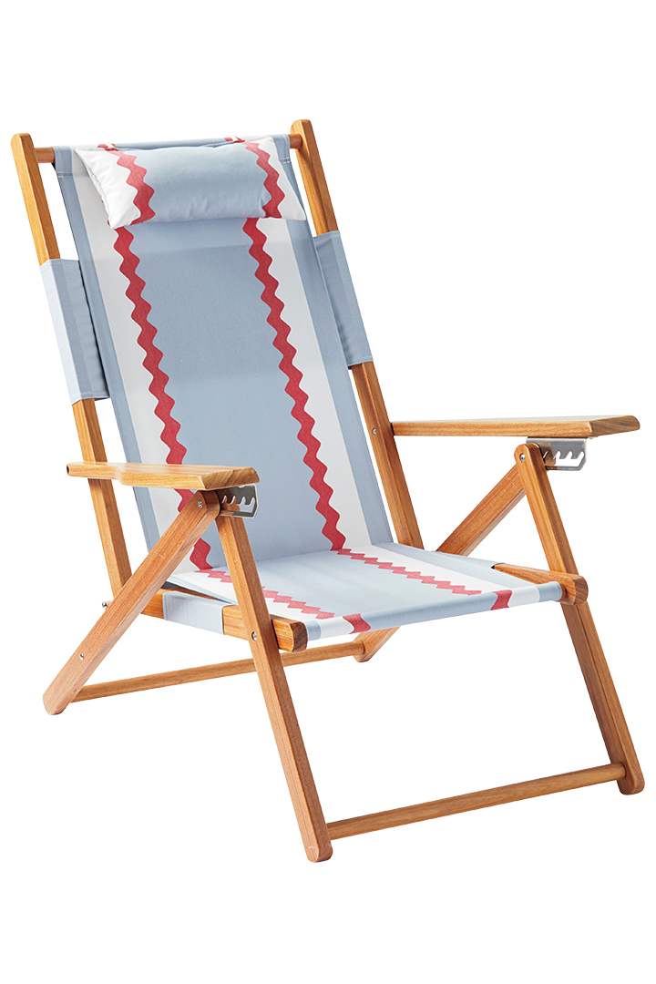 A teak wooden lounge chair with rickrack-patterned canvas.