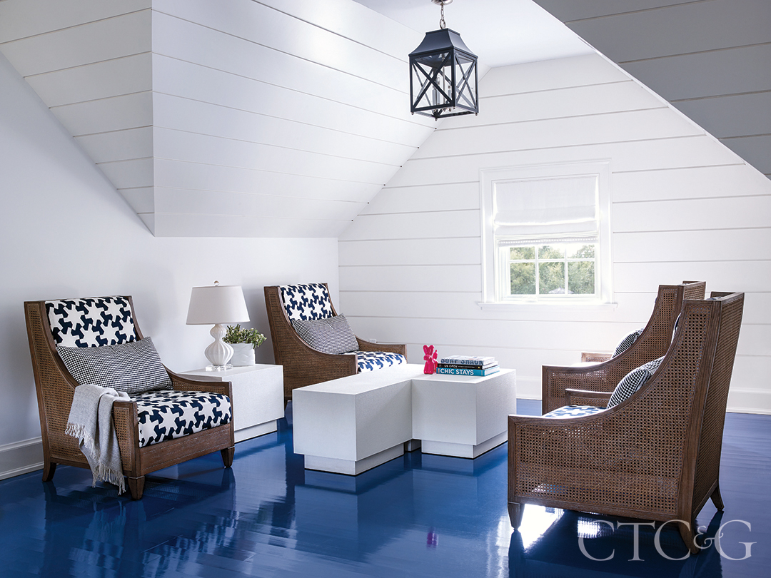 blue lacquered floors and accent patterned chair around coffee table seating area on third floor
