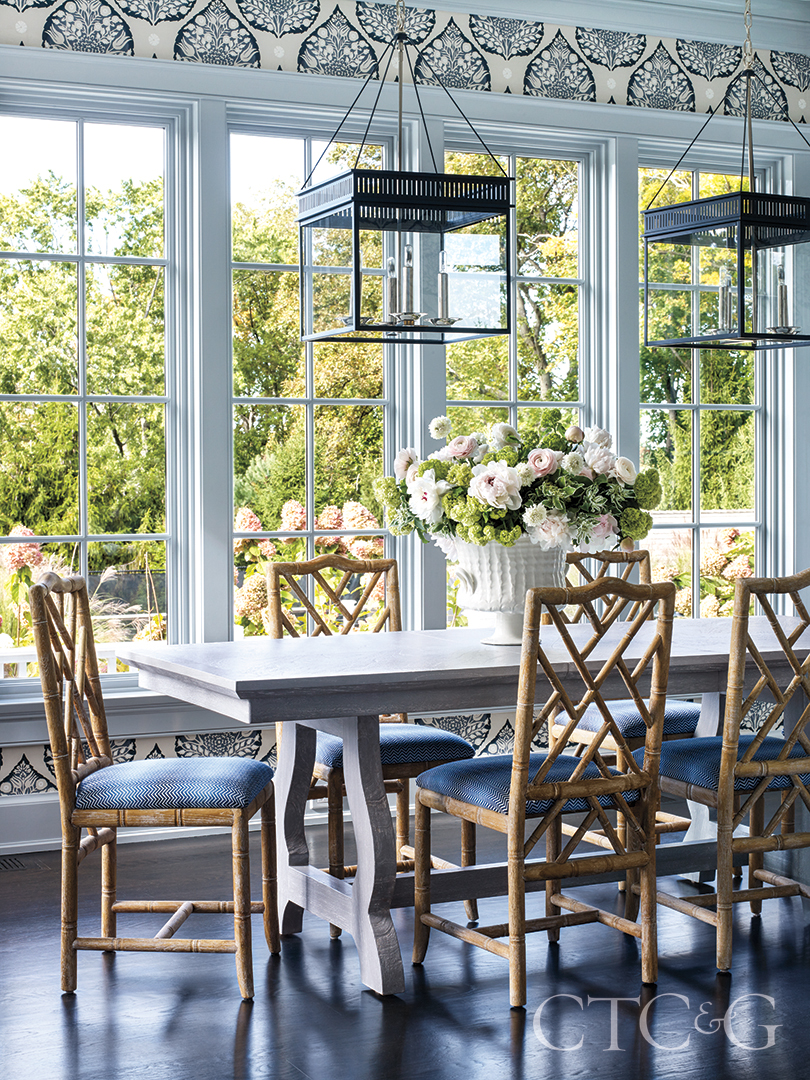 patterned accent wall and blue wooden chair around marble table create this breakfast / sunroom