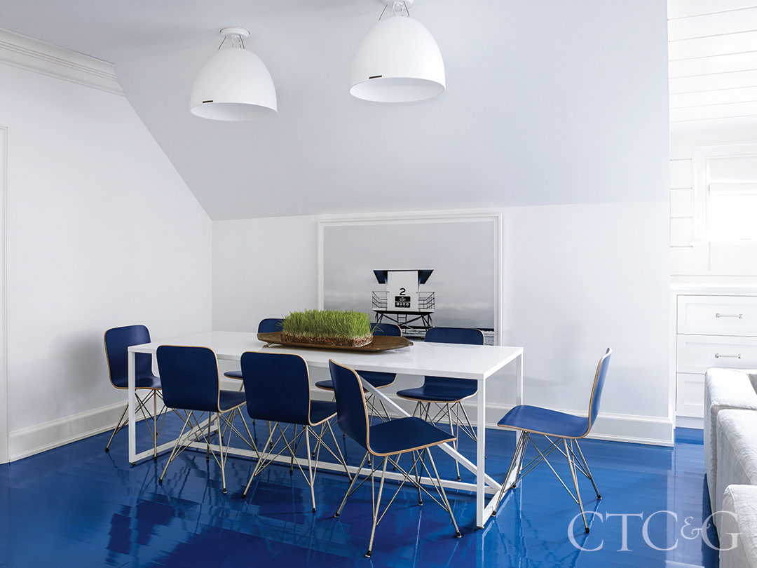 white dining table with blue dining chairs above blue lacquered floor create this third floor dining room