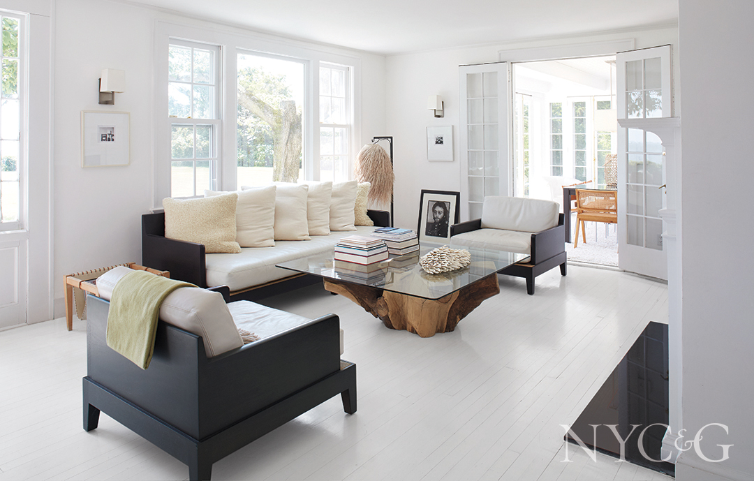 ivory leather sofa and steel and linen sconces in living room; rope and shark-tooth sculpture, and decorative photographs