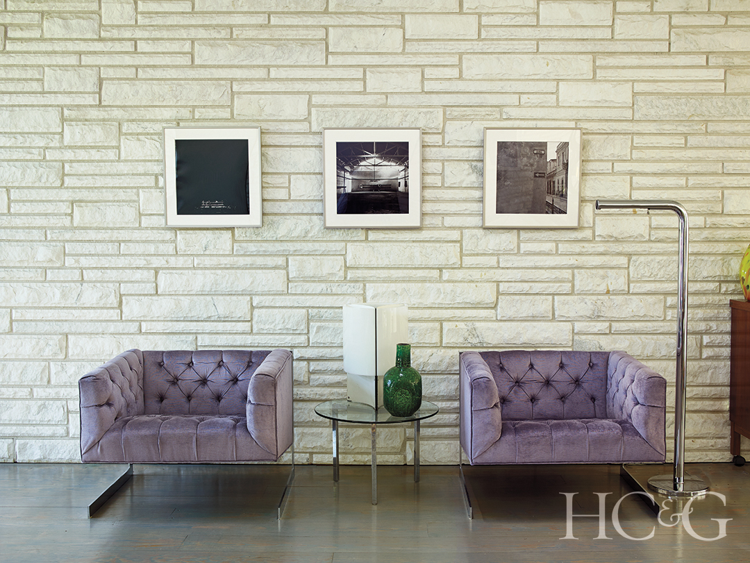 Tufted armchairs and stone wall