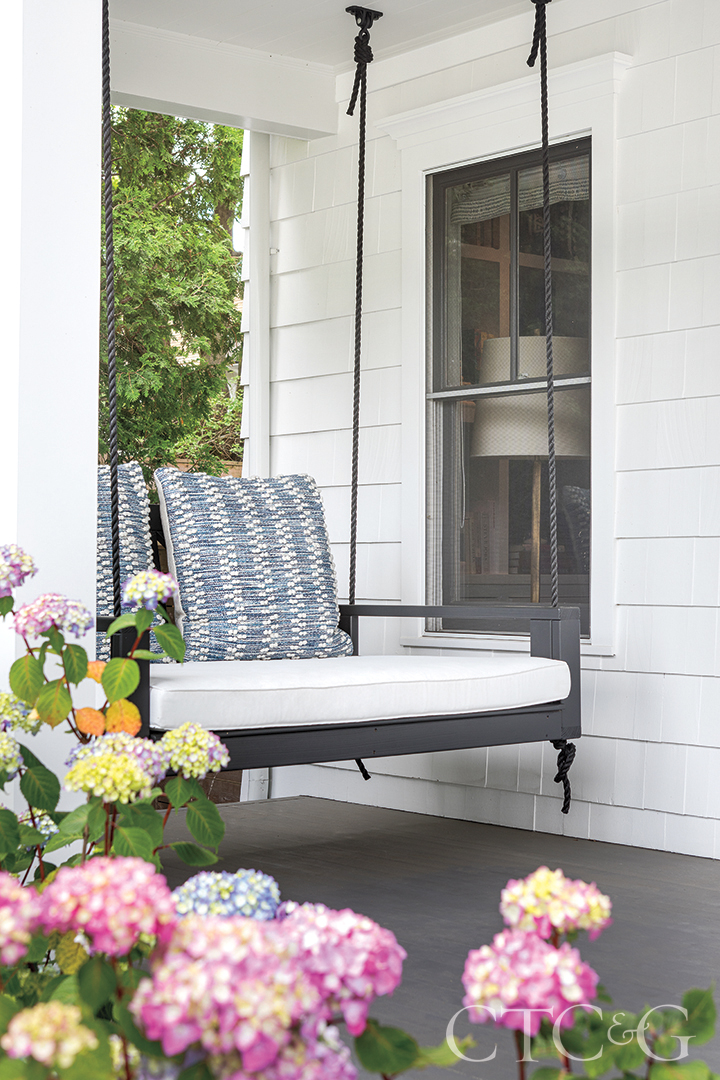 Porch swing on patio and flowers