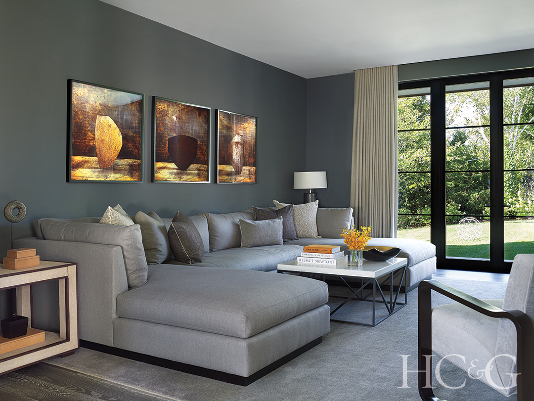 photography framed in downstairs family room; sofa, coffee table, and coffee table books