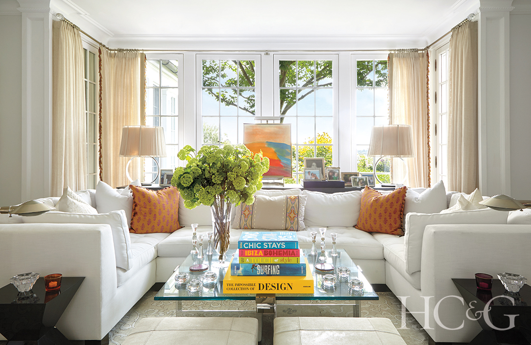 living room with custom white sofa and accent pillows; decorative table lamps and coffee table books