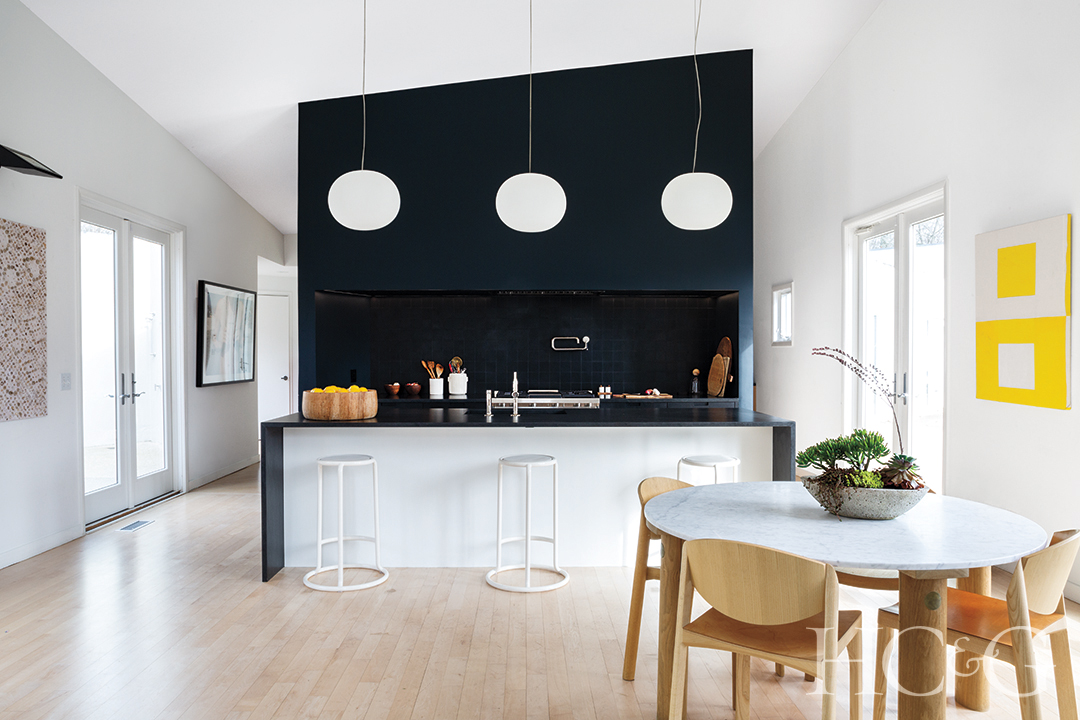 oak breakfast table and chairs in open kitchen; wall art and pantry