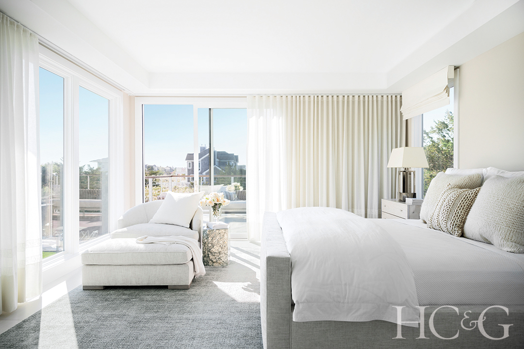 bed, chair, ottoman, and rug in main bedroom; neutral palette