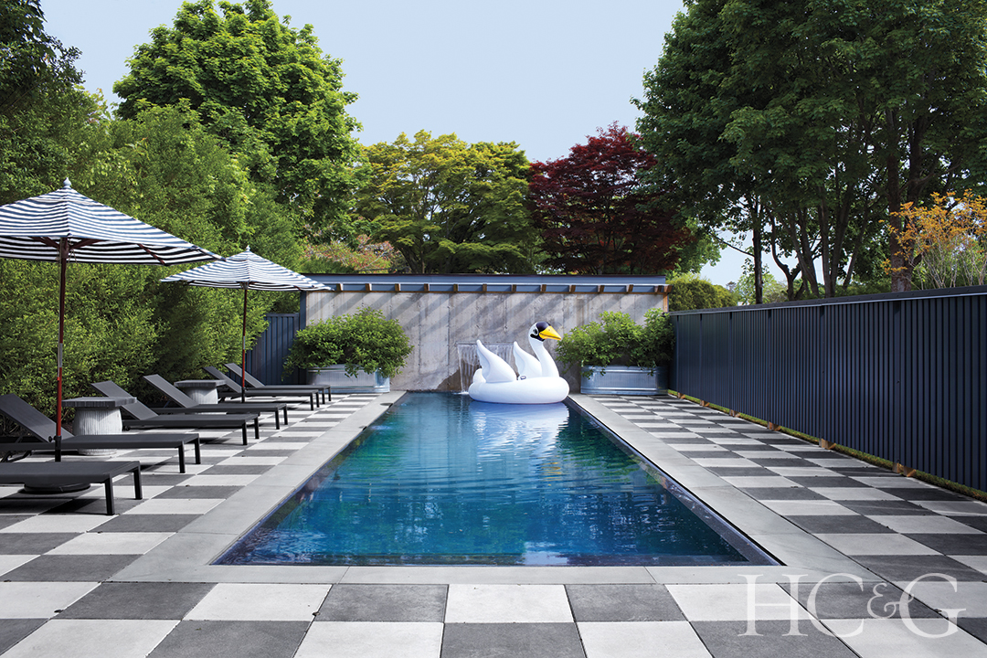 checkered cement around the pool; black chaise longues